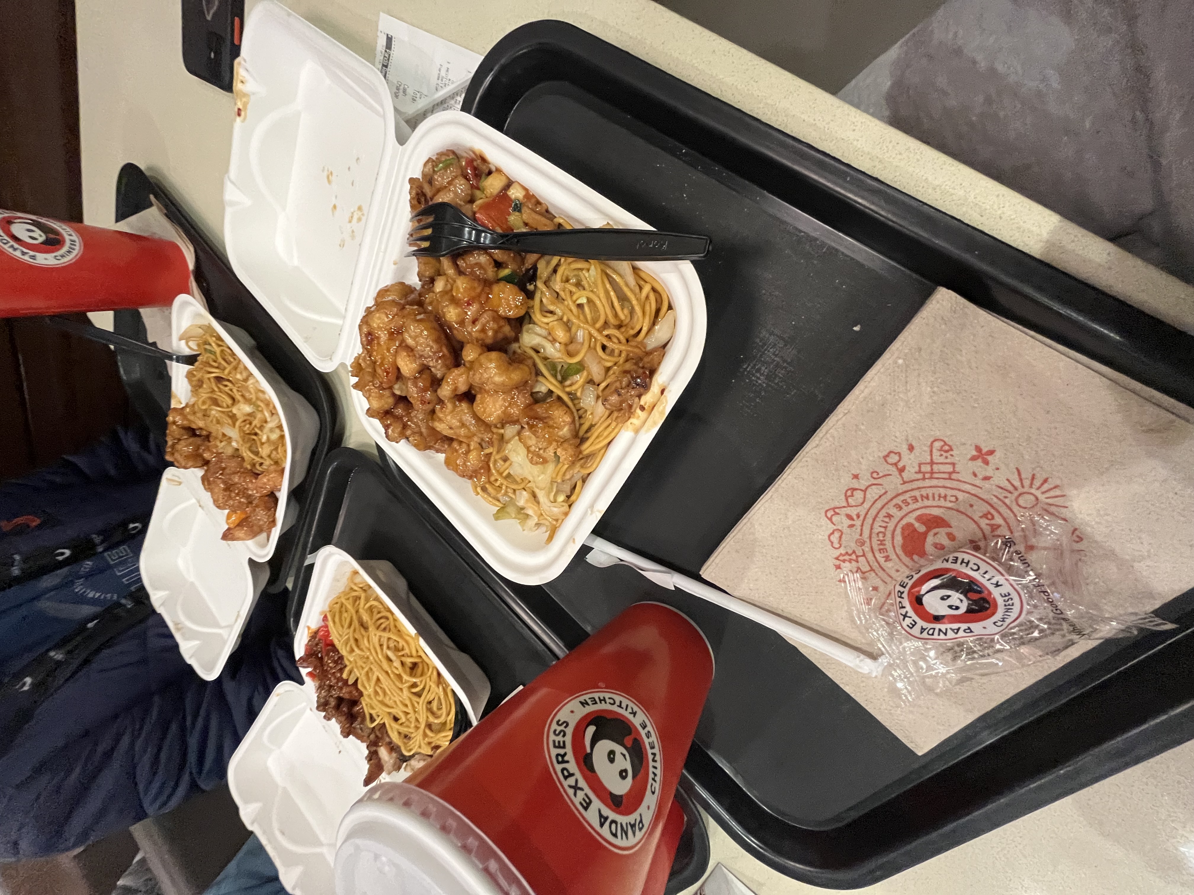 A Panda Express plate with Chow mein, orange chicken, and kung pao chicken.